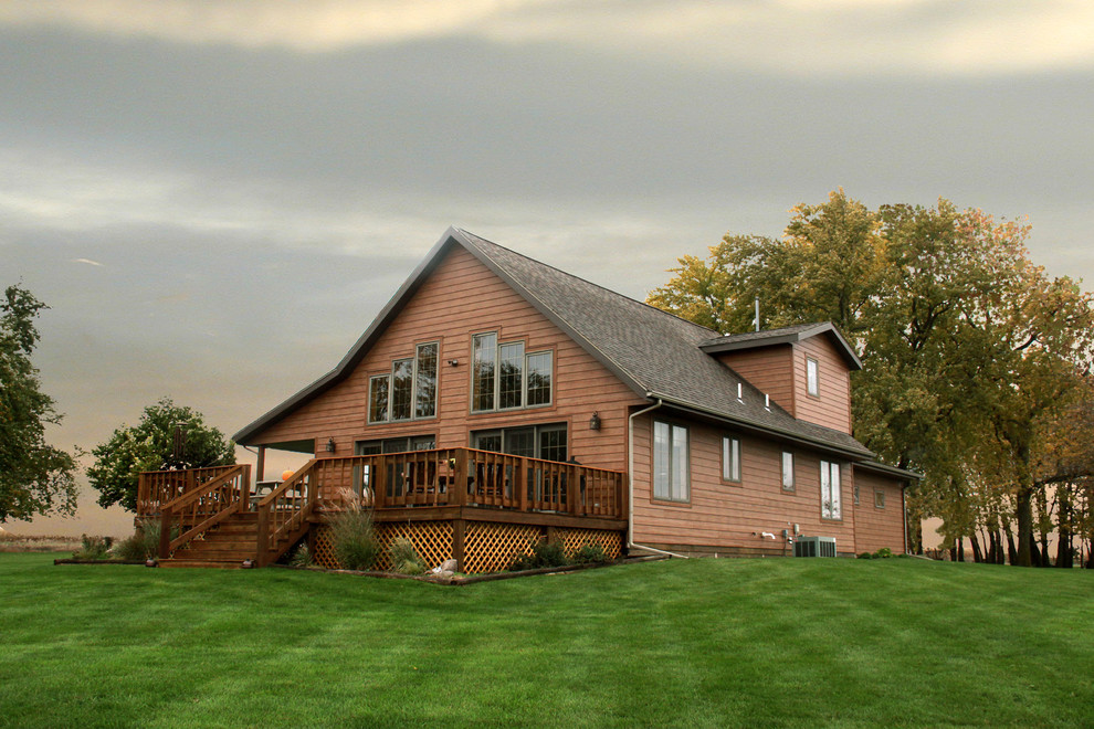 На фото: двухэтажный, деревянный, коричневый дом в классическом стиле с двускатной крышей