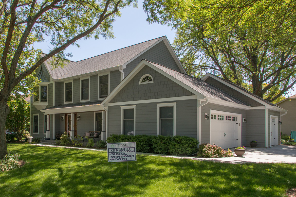 This is an example of a medium sized and gey traditional two floor detached house in Chicago with concrete fibreboard cladding, a pitched roof and a shingle roof.