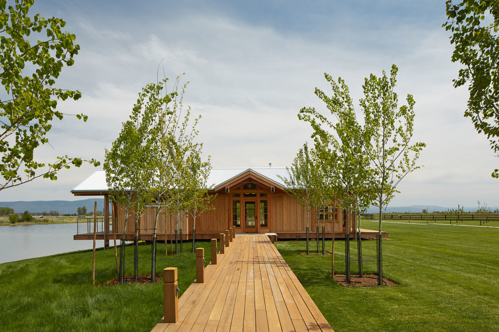 Foto de fachada campestre de una planta con revestimiento de madera y tejado a dos aguas
