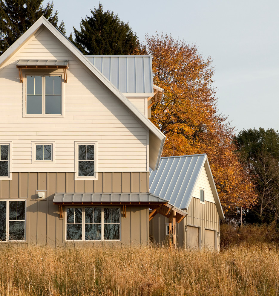 Modelo de fachada blanca de estilo de casa de campo de tamaño medio de tres plantas con revestimiento de madera y tejado a dos aguas