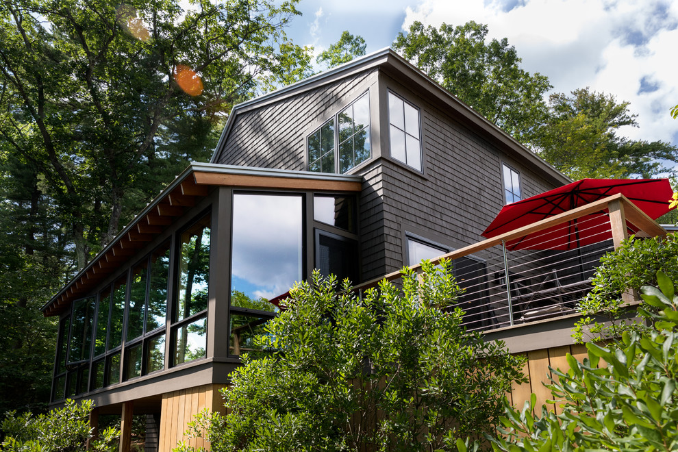 Cette photo montre une façade de maison marron bord de mer en bois de taille moyenne et à un étage avec un toit à deux pans.
