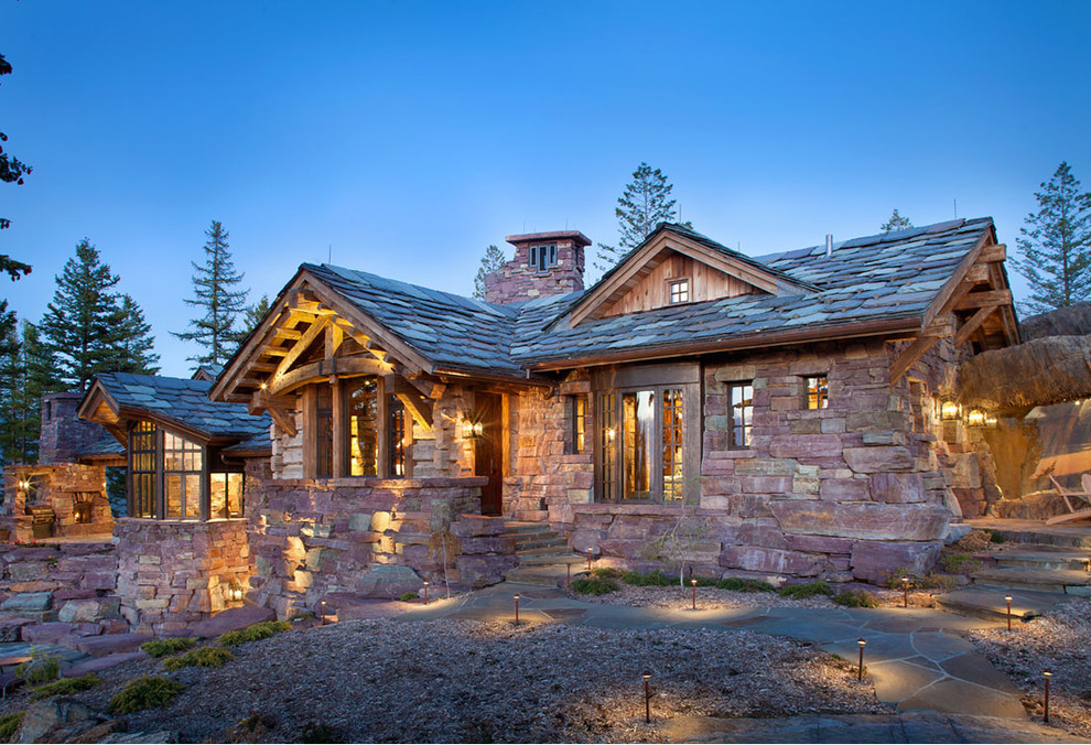 Design ideas for a large and brown rustic house exterior in Other with stone cladding.