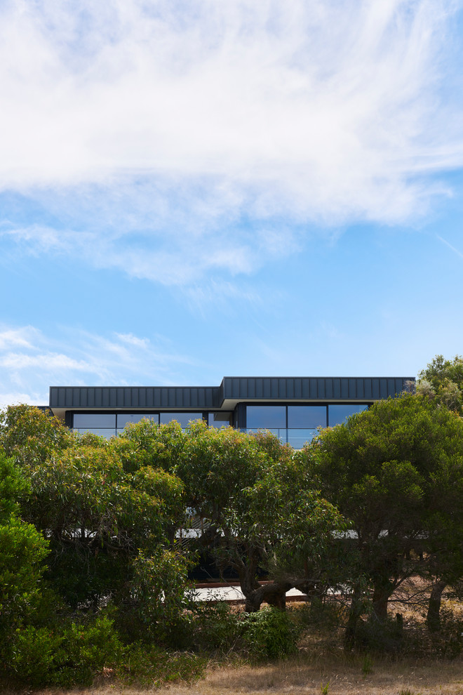 Mittelgroßes, Zweistöckiges Modernes Einfamilienhaus mit Metallfassade, schwarzer Fassadenfarbe, Flachdach und Blechdach in Geelong