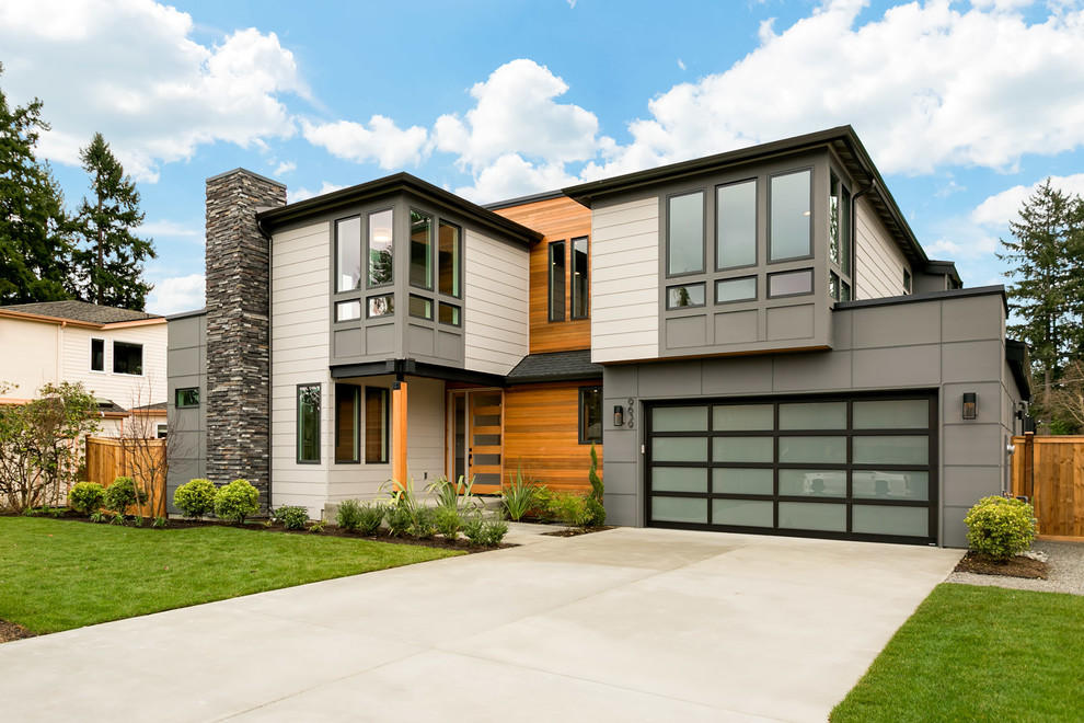 Cette photo montre une grande façade de maison grise tendance à un étage avec un revêtement mixte et un toit plat.