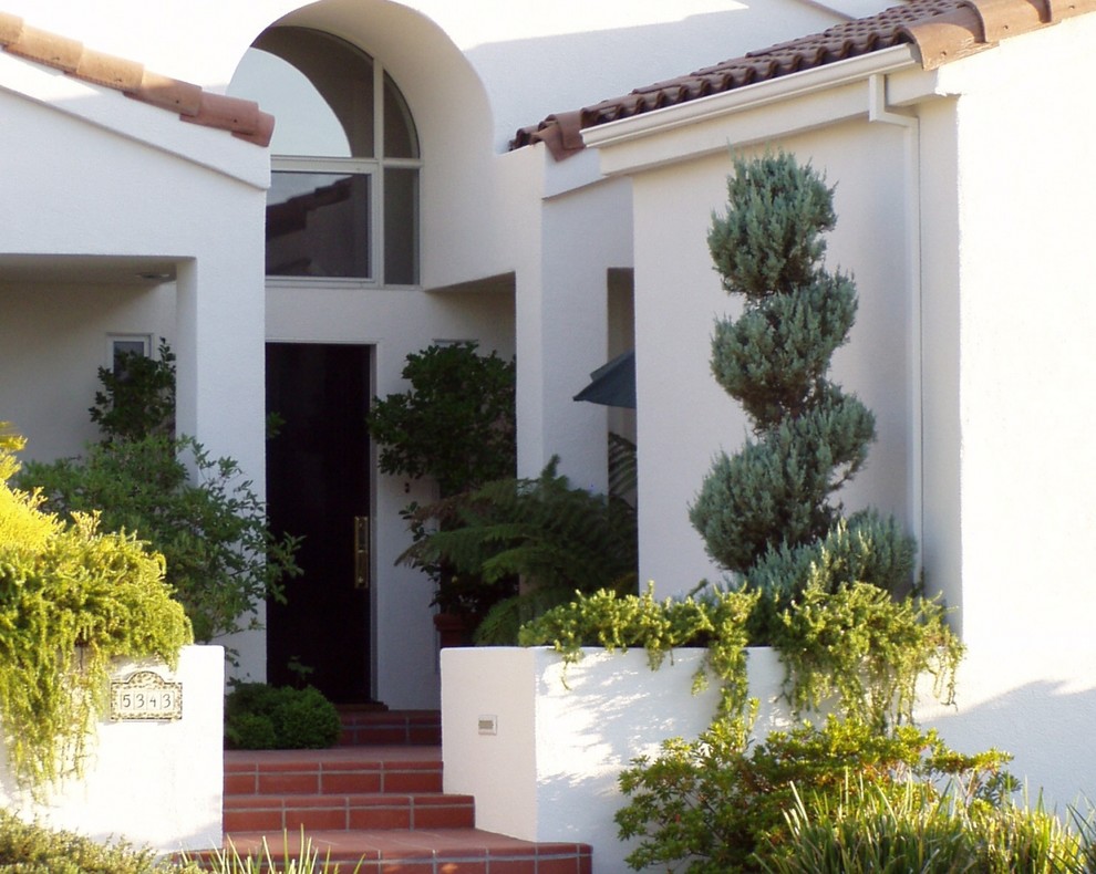 Example of a mid-sized tuscan white one-story stucco exterior home design in Sacramento with a tile roof