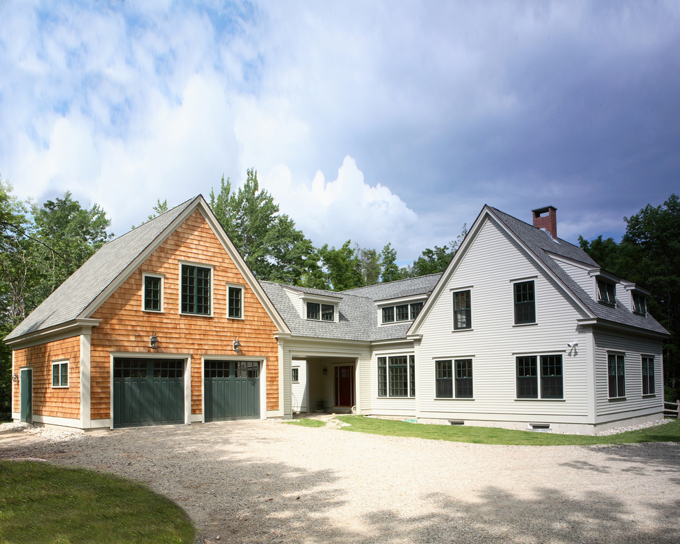 Immagine della facciata di una casa country a due piani con rivestimenti misti