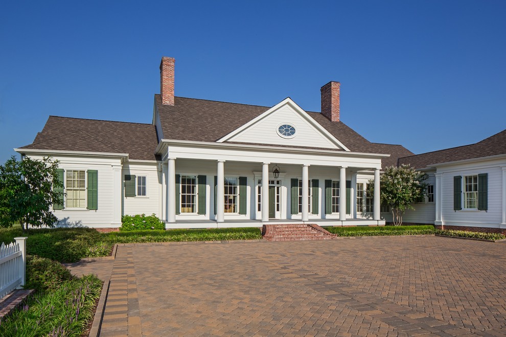 Пример оригинального дизайна: одноэтажный, деревянный, белый частный загородный дом среднего размера в классическом стиле с двускатной крышей и крышей из гибкой черепицы