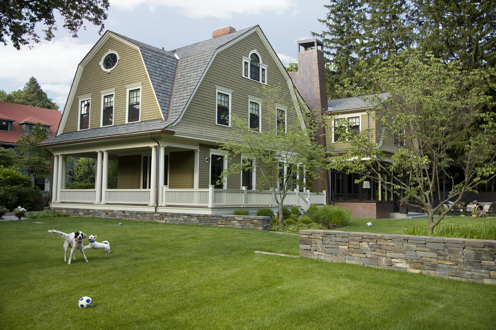 Photo of a large traditional house exterior in Boston with three floors, wood cladding and a mansard roof.