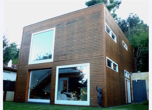 Inspiration for a small contemporary two floor house exterior in Barcelona with wood cladding.