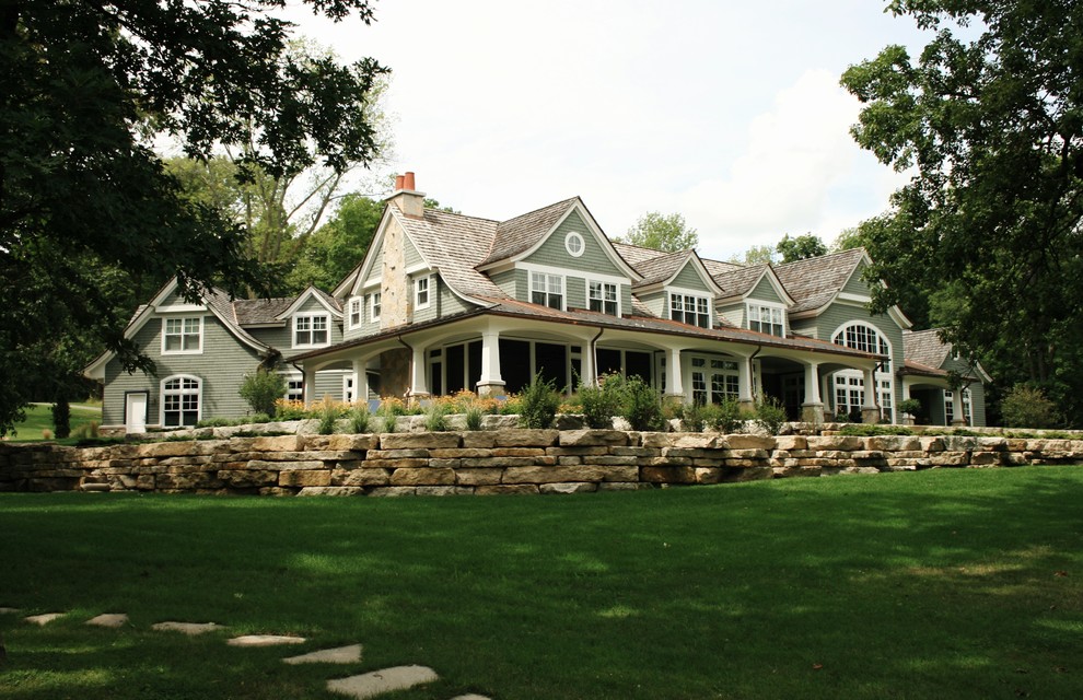 На фото: огромный, двухэтажный, деревянный, зеленый дом в классическом стиле с двускатной крышей