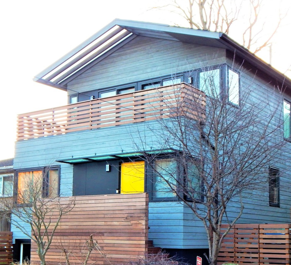 Immagine della villa piccola grigia moderna a tre piani con rivestimento in legno e tetto a padiglione