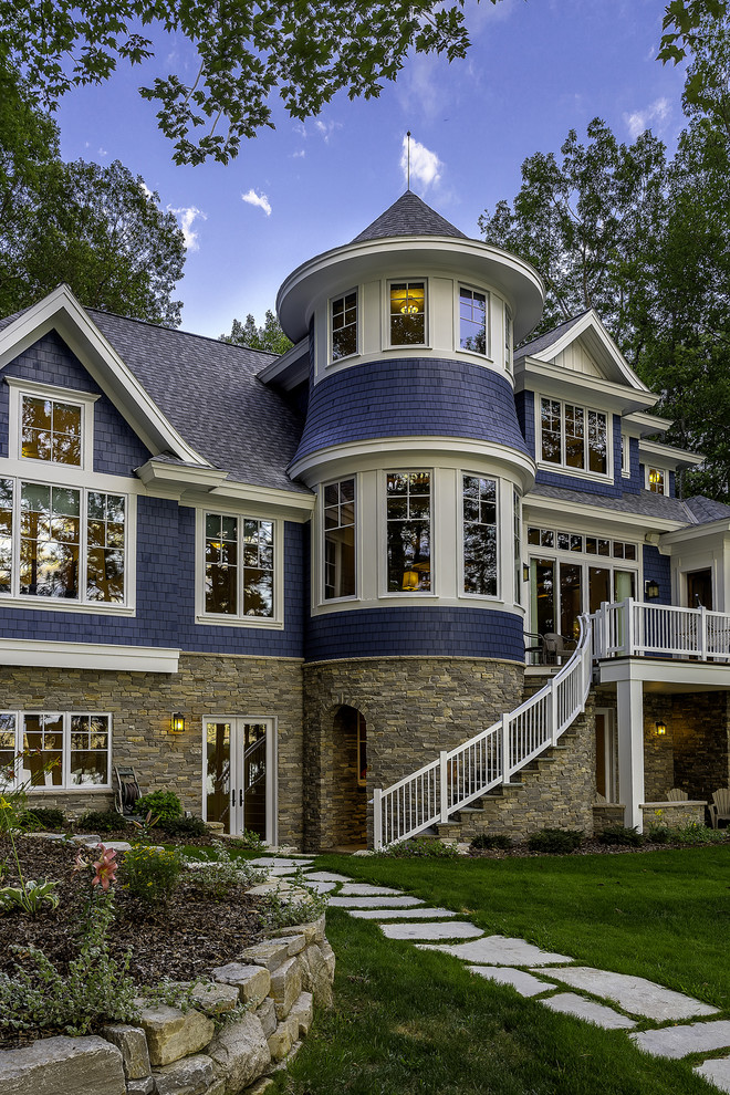 Foto della facciata di una casa blu vittoriana a tre piani di medie dimensioni con rivestimento in legno e tetto a padiglione