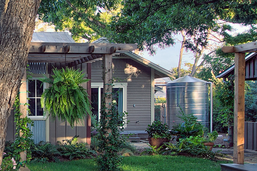 Einstöckiges, Kleines Uriges Einfamilienhaus mit Faserzement-Fassade, brauner Fassadenfarbe, Satteldach und Blechdach in Austin