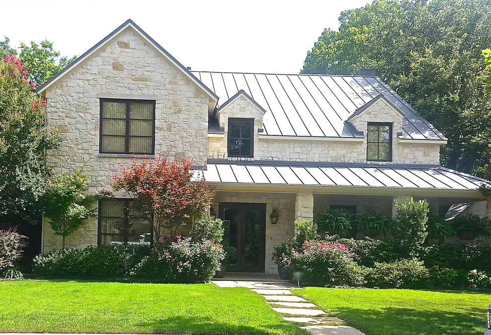 Foto de fachada de casa beige clásica de tamaño medio de dos plantas con revestimiento de piedra, tejado a dos aguas y tejado de metal