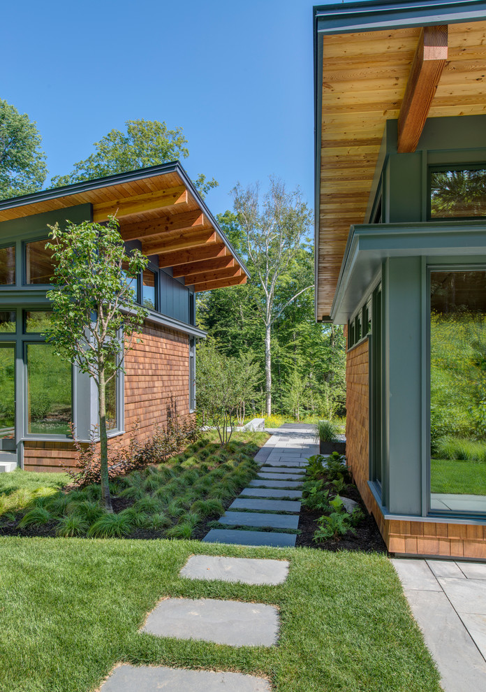 Idées déco pour une petite façade de maison marron contemporaine en bois de plain-pied avec un toit en appentis.