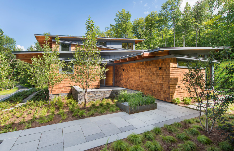 Diseño de fachada marrón actual de tamaño medio de dos plantas con revestimiento de madera y tejado de un solo tendido