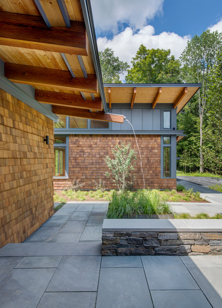 Ejemplo de fachada marrón contemporánea de tamaño medio de dos plantas con revestimiento de madera y tejado de un solo tendido