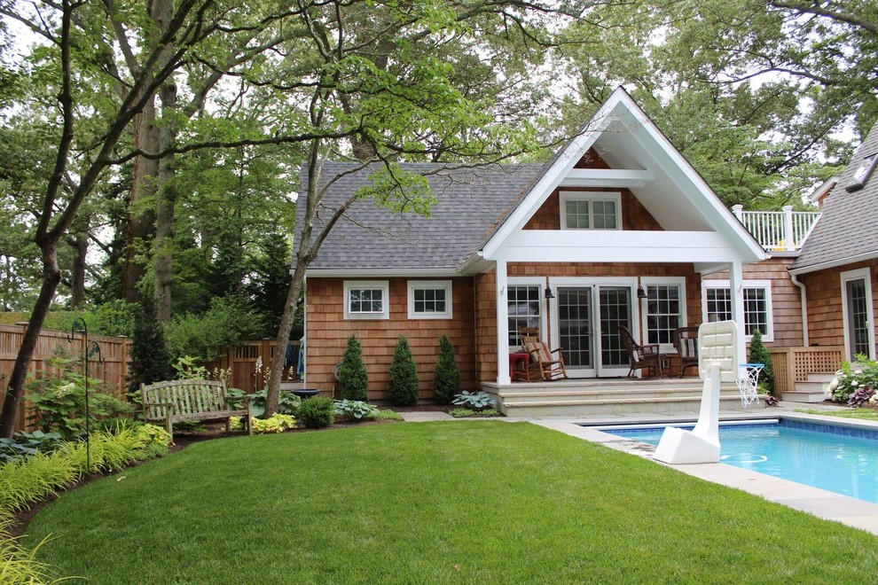 Cette photo montre une façade de maison marron chic en bois de plain-pied avec un toit à deux pans et un toit en shingle.