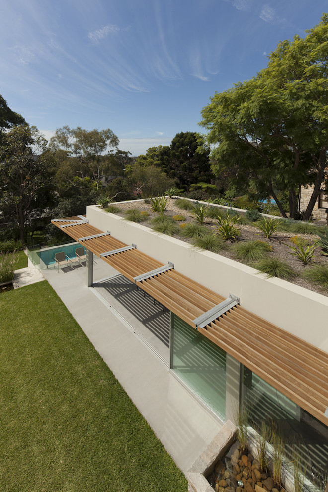 Medium sized and white modern two floor detached house in Sydney with a green roof.