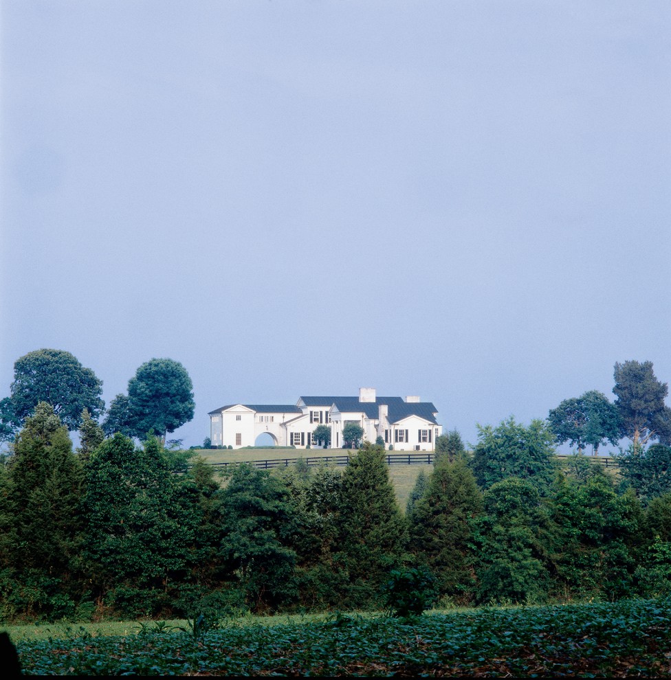Foto på ett lantligt vitt hus, med blandad fasad