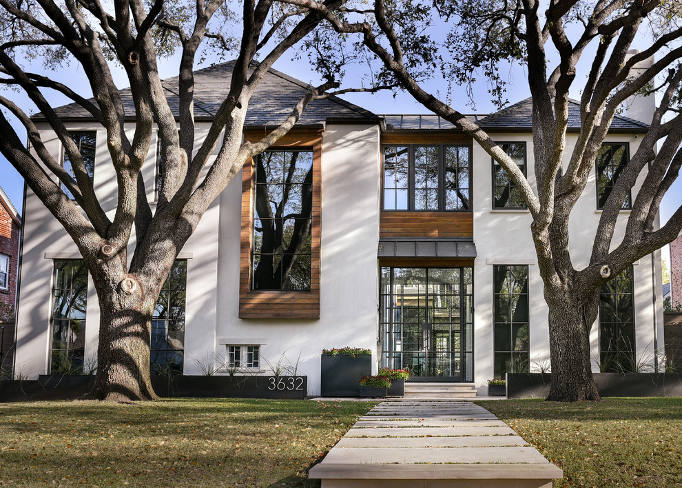 Large and beige contemporary two floor house exterior in Dallas with stone cladding and a hip roof.