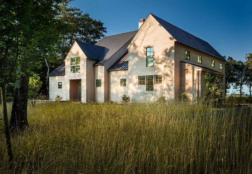 Inspiration pour une grande façade de maison beige rustique en bois à un étage avec un toit à deux pans.