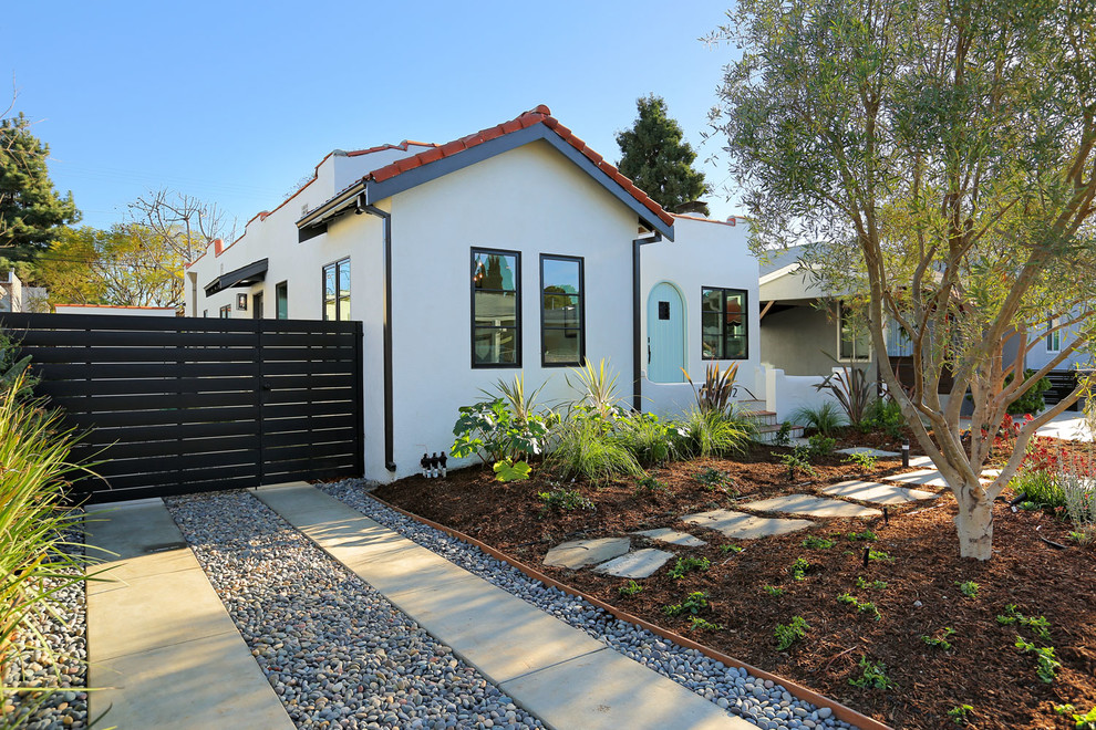 На фото: маленький, одноэтажный, белый частный загородный дом в стиле неоклассика (современная классика) с облицовкой из цементной штукатурки, двускатной крышей и черепичной крышей для на участке и в саду с