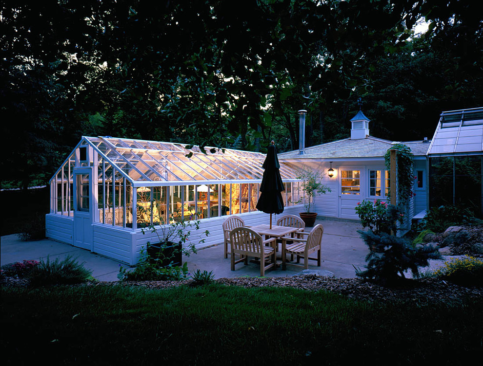 Immagine della villa grande bianca classica a un piano con rivestimento in vetro, tetto a capanna e copertura mista