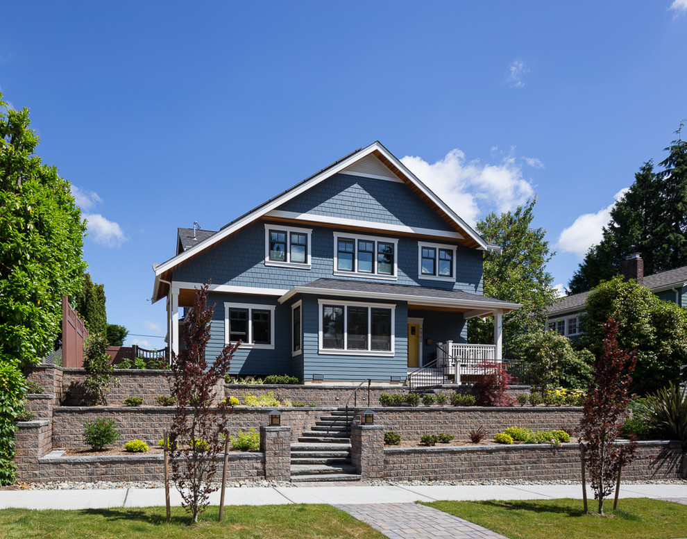 Diseño de fachada de casa azul de estilo americano de tamaño medio de dos plantas con revestimiento de madera, tejado a dos aguas y tejado de teja de madera