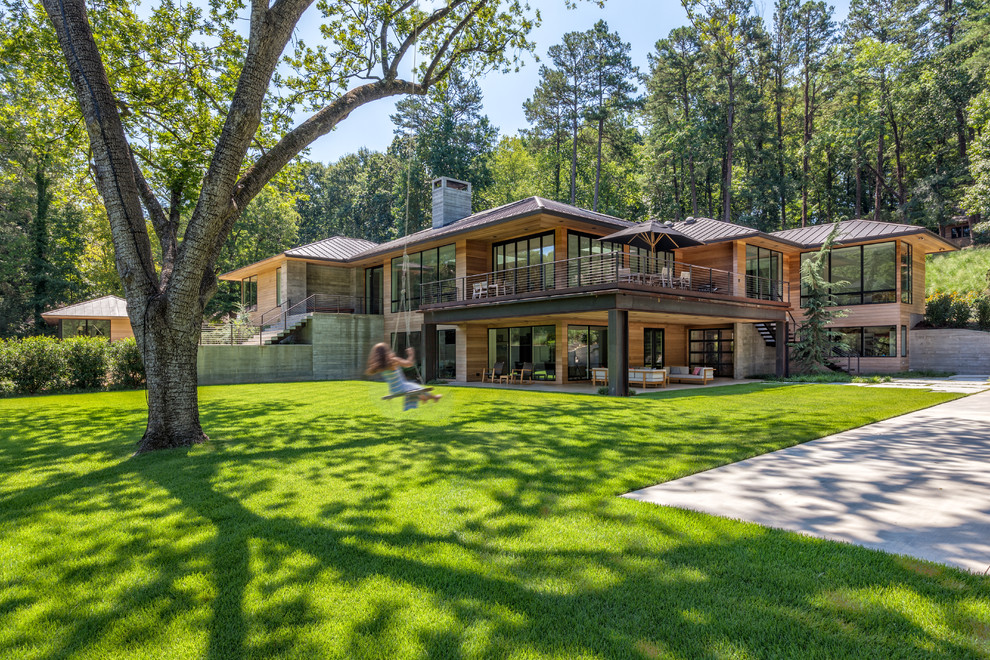 Photo of a large contemporary two floor house exterior in Charleston with a hip roof and wood cladding.