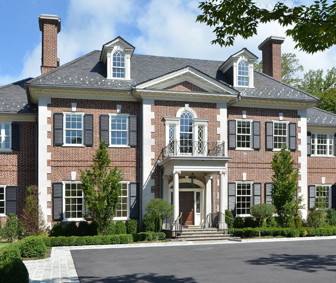 Inspiration for a large timeless two-story brick exterior home remodel in New York with a shingle roof