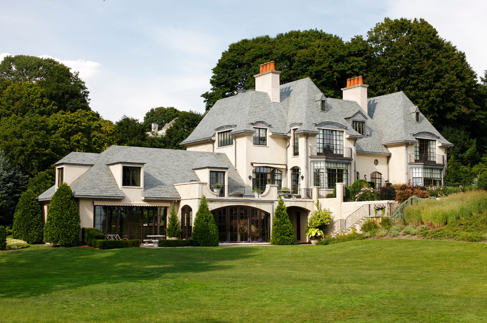 Huge elegant beige three-story exterior home photo in Atlanta with a hip roof