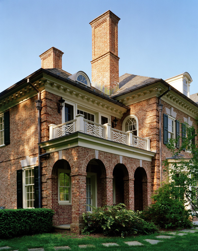 Huge elegant red three-story brick house exterior photo in New York with a hip roof and a shingle roof