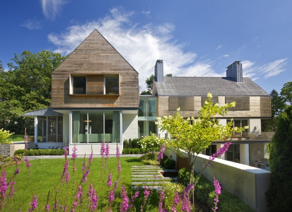 Imagen de fachada marrón contemporánea grande de tres plantas con revestimiento de madera y tejado a dos aguas