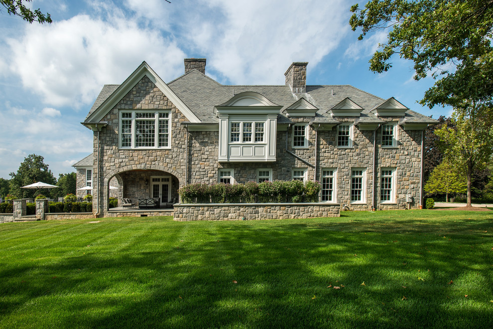 This is an example of a traditional house exterior in New York with three floors, stone cladding and a pitched roof.