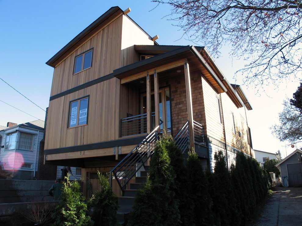 Example of a mid-sized trendy brown three-story wood exterior home design in Seattle with a shed roof