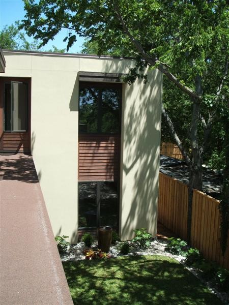 Cette image montre une grande façade de maison multicolore minimaliste à un étage avec un revêtement mixte et un toit plat.
