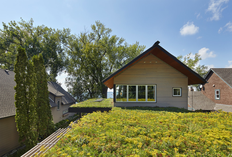 Идея дизайна: маленький, двухэтажный, деревянный частный загородный дом в стиле модернизм с плоской крышей и крышей из смешанных материалов для на участке и в саду