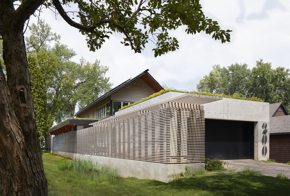 Inspiration för små moderna grå hus, med två våningar, blandad fasad, platt tak och levande tak