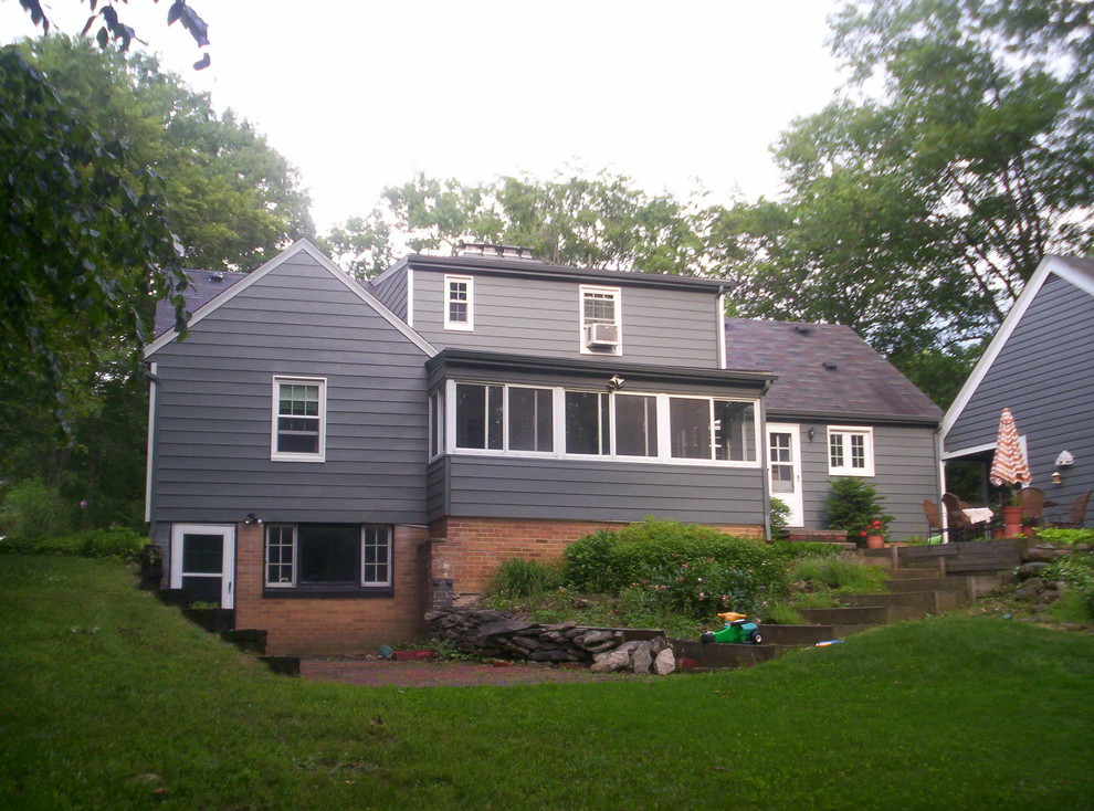 Modelo de fachada gris de estilo de casa de campo de tamaño medio de tres plantas con revestimiento de madera y tejado a dos aguas