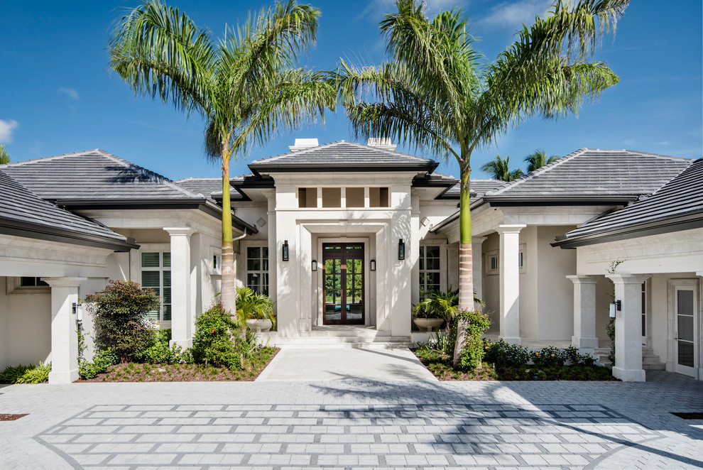 Inspiration for a large transitional white one-story stucco exterior home remodel in Miami with a hip roof
