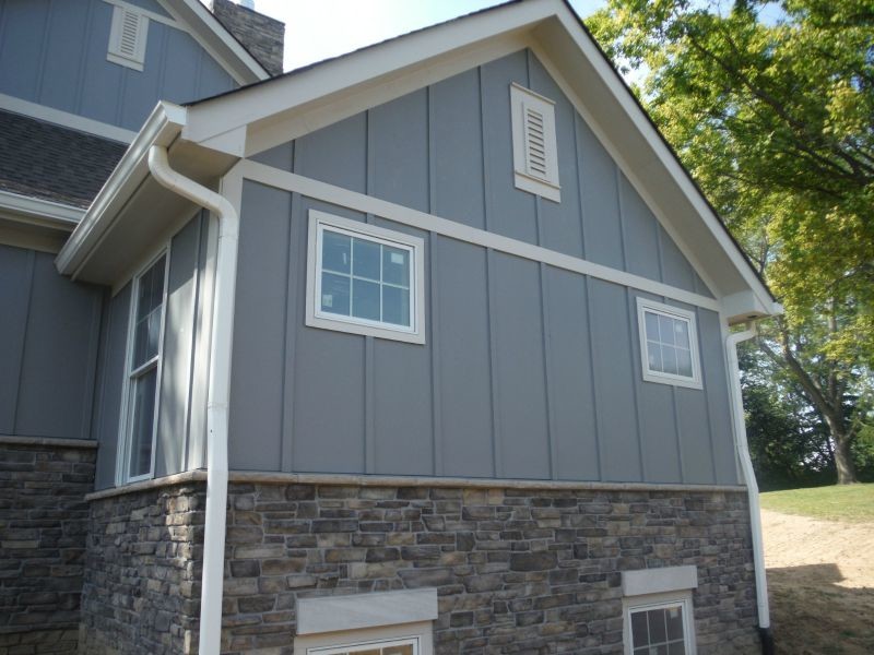 Exemple d'une grande façade de maison grise chic en panneau de béton fibré à un étage.