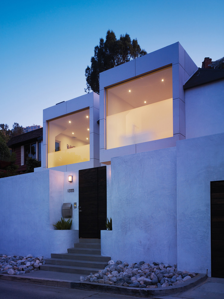 Idées déco pour une petite façade de maison blanche moderne en stuc à un étage avec un toit plat.