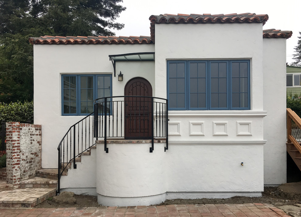 Idee per la villa piccola bianca mediterranea a un piano con rivestimento in stucco, tetto piano e copertura mista
