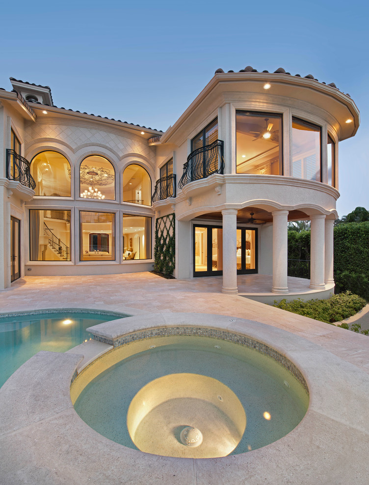 Example of a large transitional beige two-story stucco exterior home design in Miami