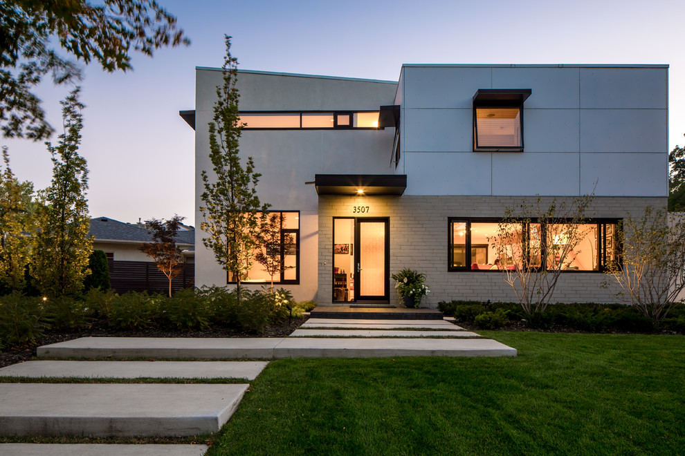 Inspiration pour une grande façade de maison grise design à un étage avec un revêtement mixte et un toit plat.