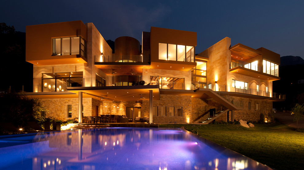 Пример оригинального дизайна: большой, коричневый дом в стиле модернизм с разными уровнями и облицовкой из цементной штукатурки