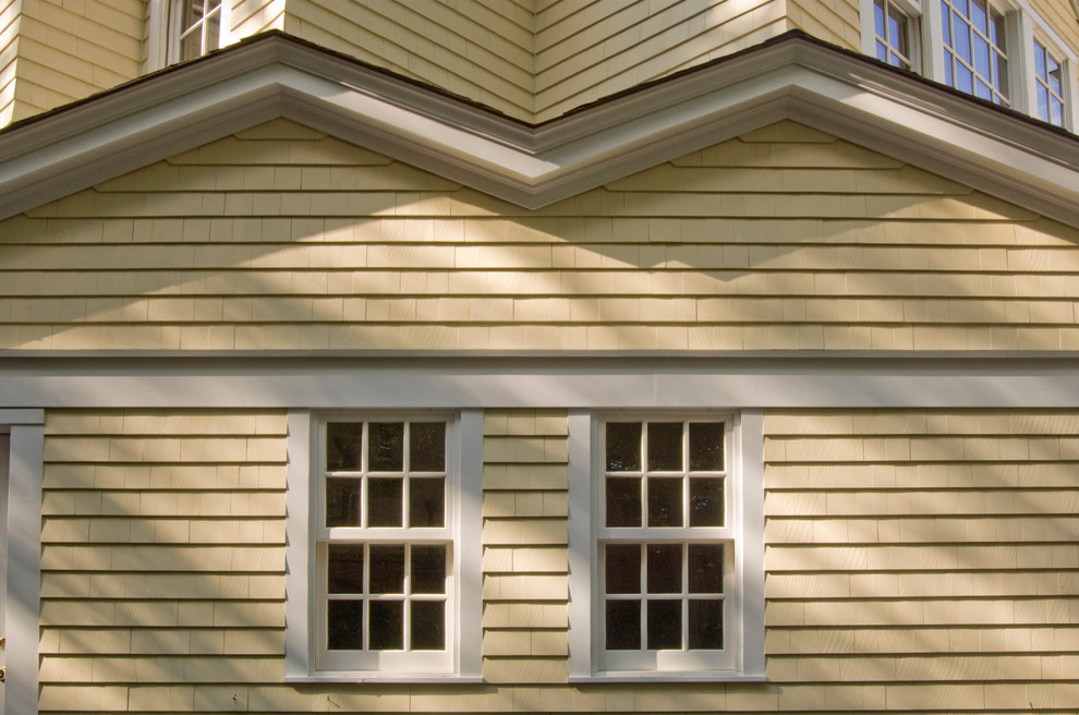 Design ideas for a large and yellow classic two floor house exterior in Boston with vinyl cladding.