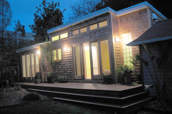 Idées déco pour une petite façade de maison marron moderne en bois de plain-pied avec un toit en appentis.