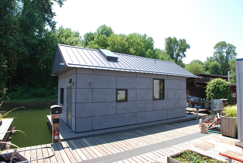 Foto på ett litet funkis grått hus, med allt i ett plan, metallfasad och sadeltak